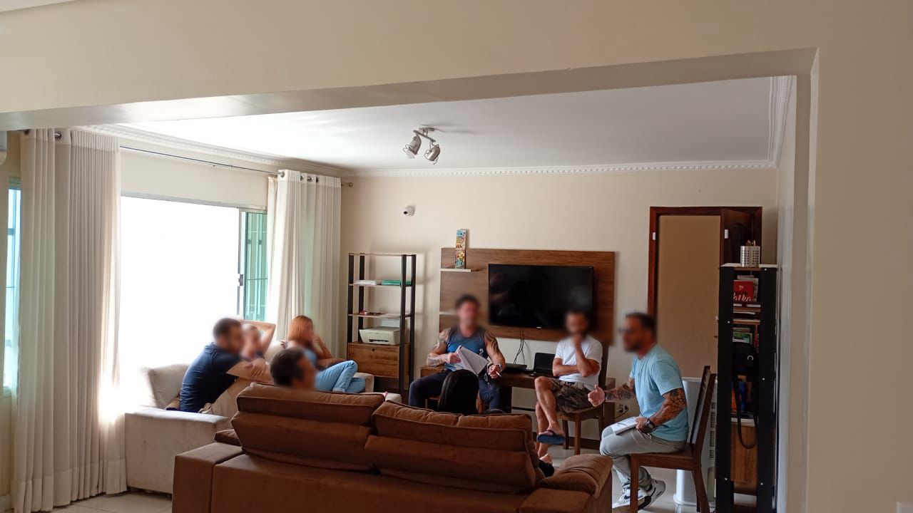 sala de estar com pessoas de uma familia conversando pos almoço