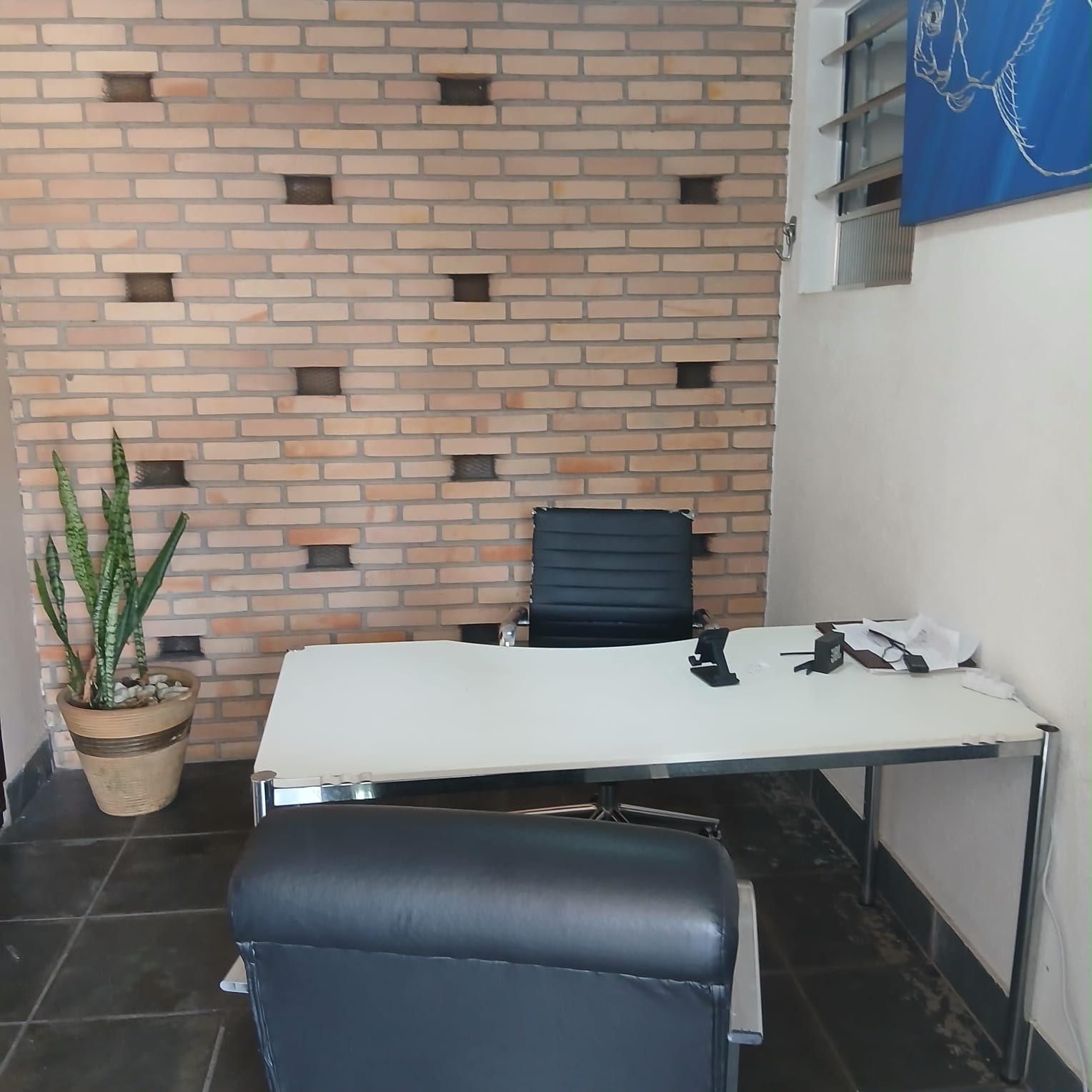 Sala de atendimento individual com mesa e poltronas